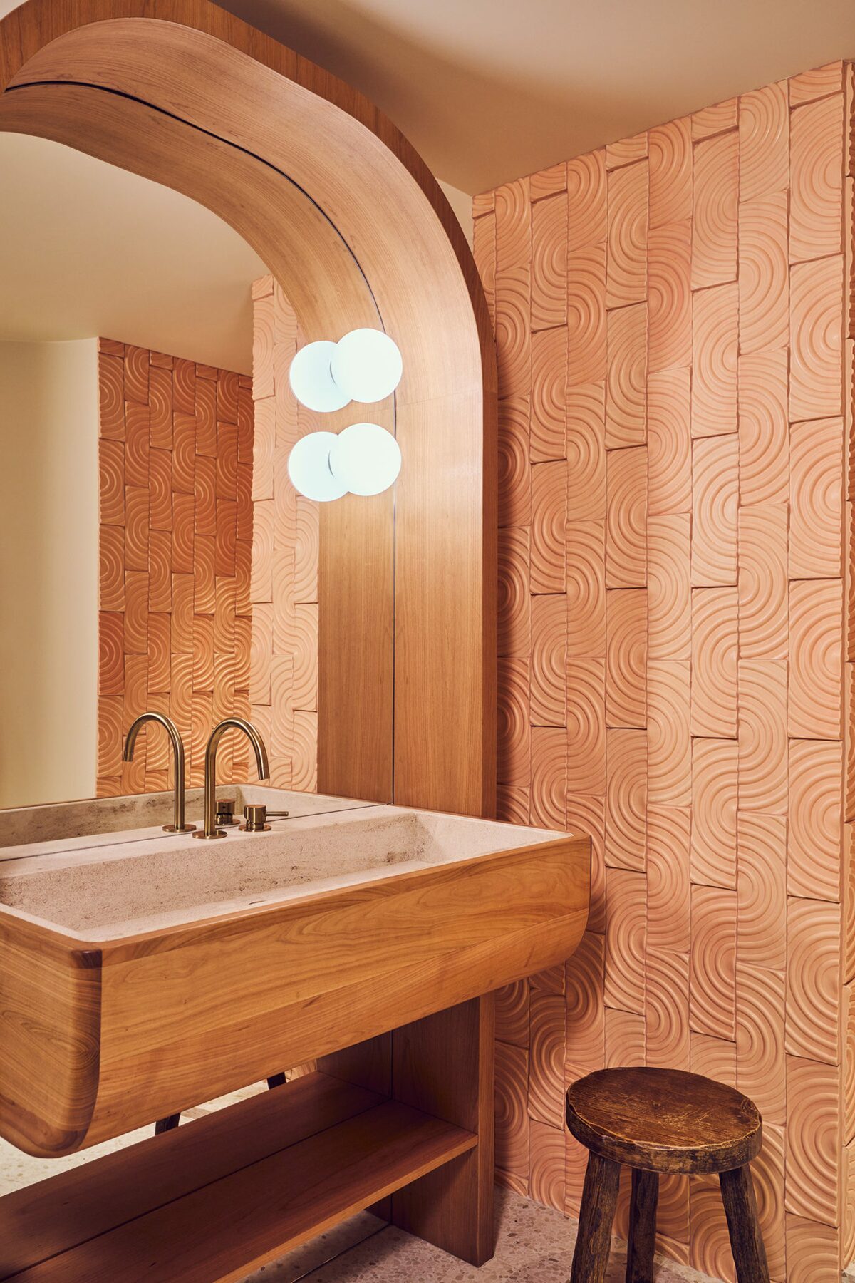 Pièce d'eau avec applique globulaire, tabouret en bois moderniste, vaste en bois et pierre, carrelage en relief - Projet Montalembert réalisé par Batiik Studio