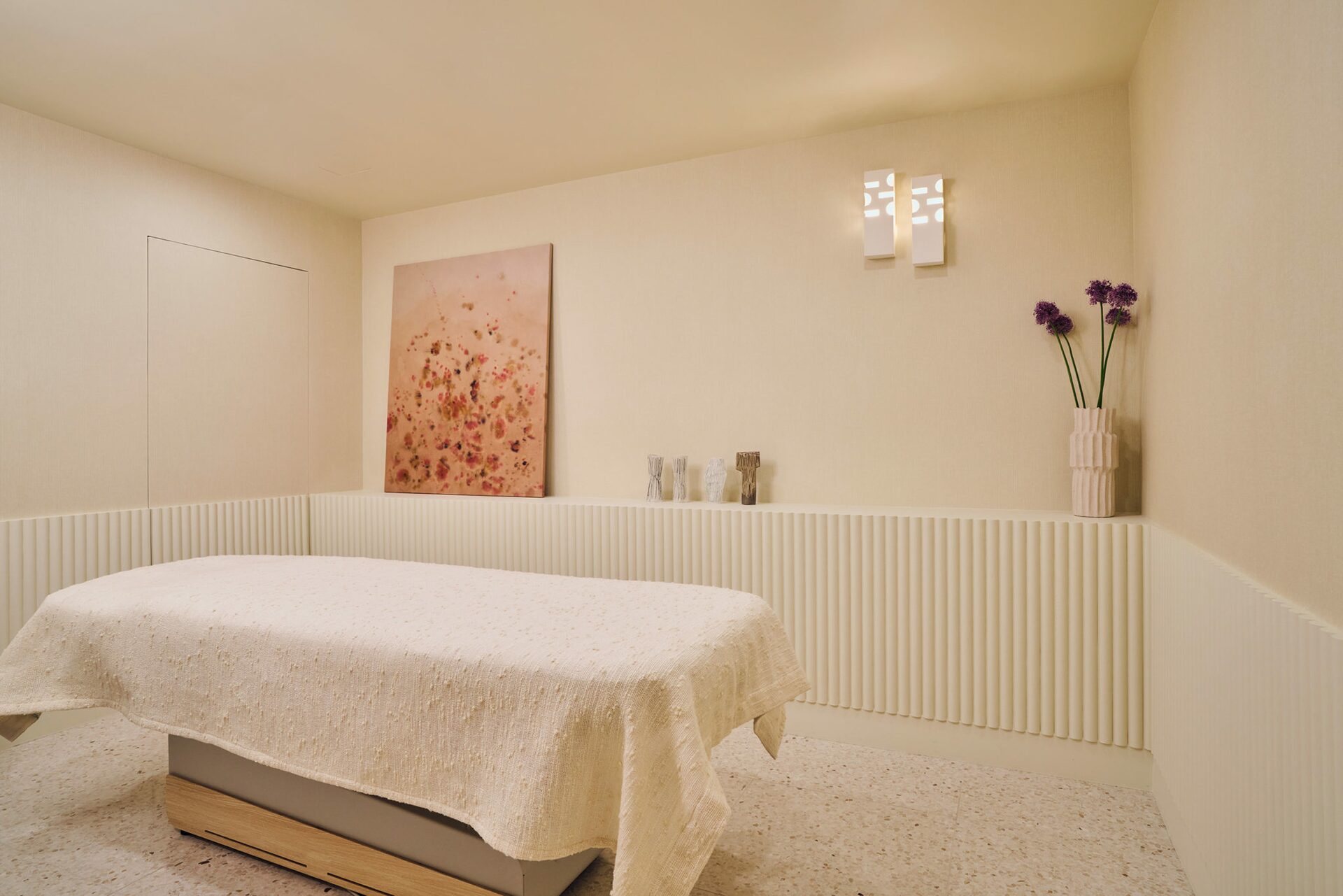 Salle de massage avec rideau en textile en relief et porte en bois sculptée - Projet Montalembert réalisé par Batiik Studio