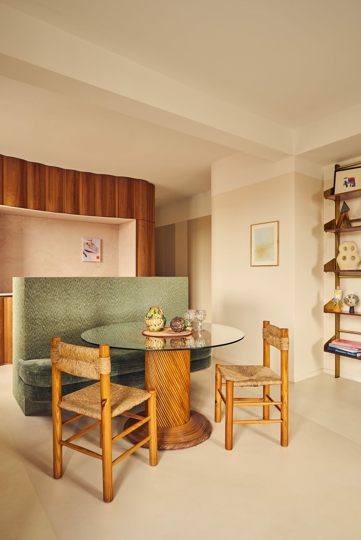 Appartement parisien. Sol en résine, chaise en rotin, table de salle à manger avec plateau en verre. Banquette en tissu vert. Cuisine en bois. Projet Saint-Gervais réalisé par Batiik Studio.