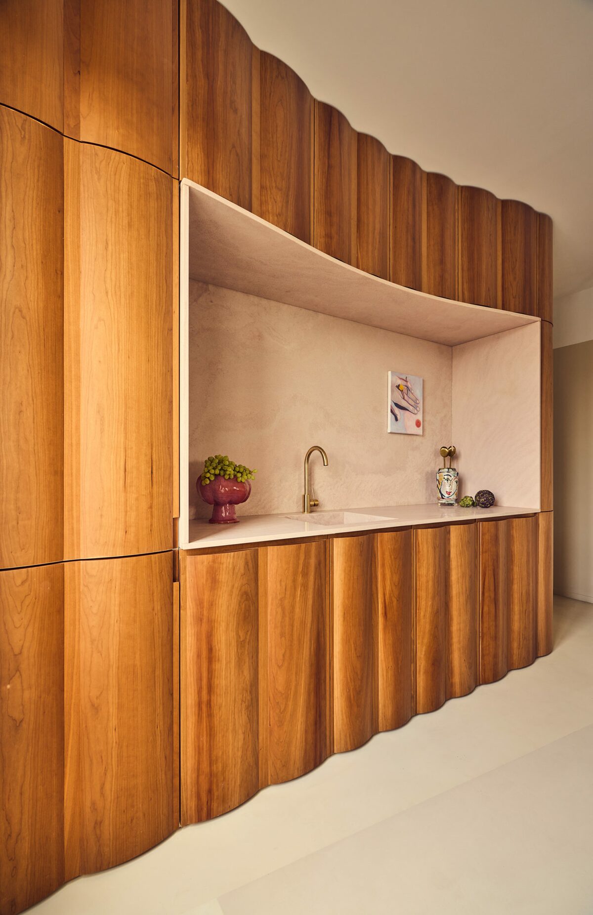 Cuisine en bois et pierre rose. Projet Saint-Gervais à Paris réalisé par Batiik Studio.