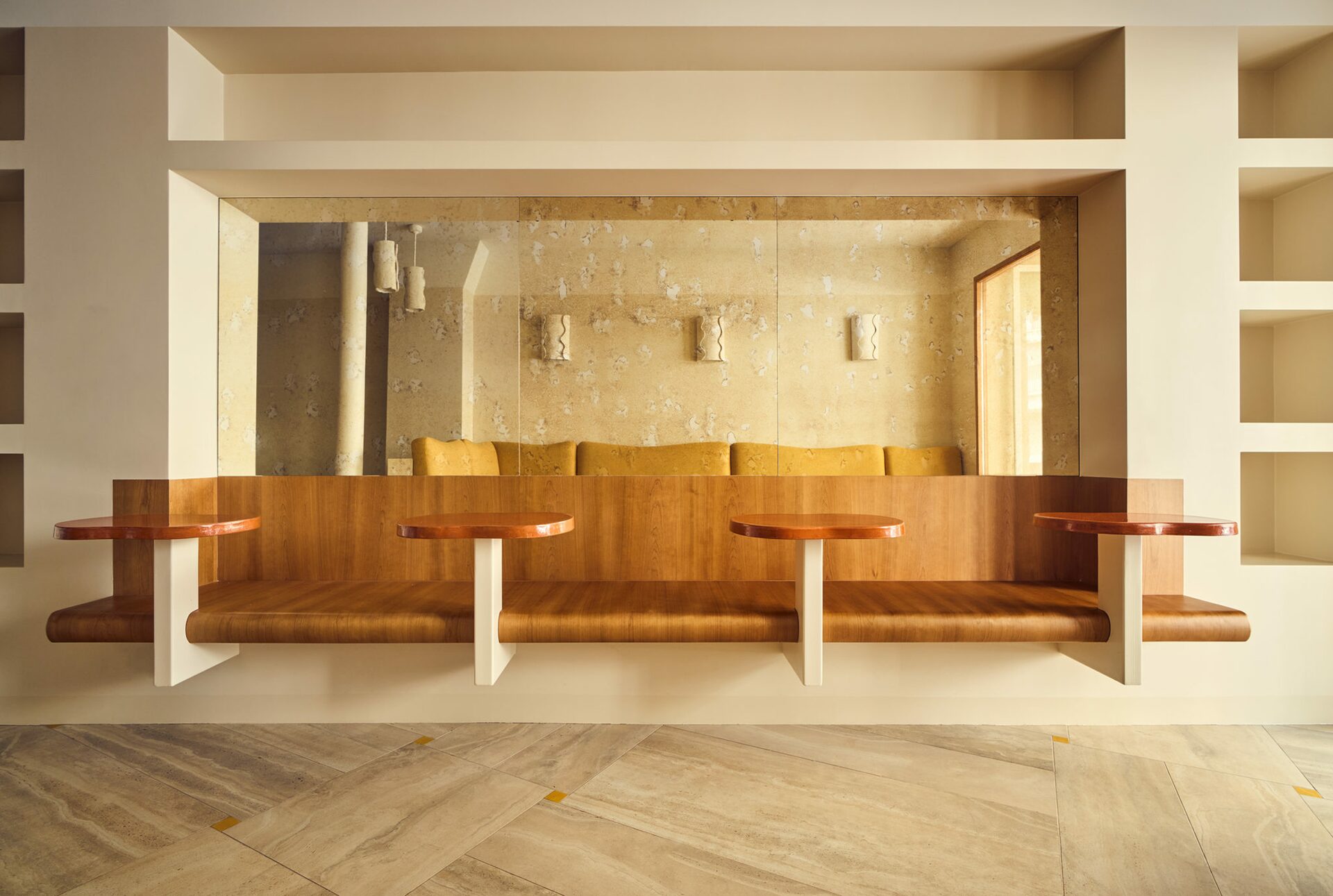 Banquette en merisier deux en un avec ses tablettes d’appoint. Miroir piqué et étagère niches murales. Projet Love réalisé par Batiik Studio.