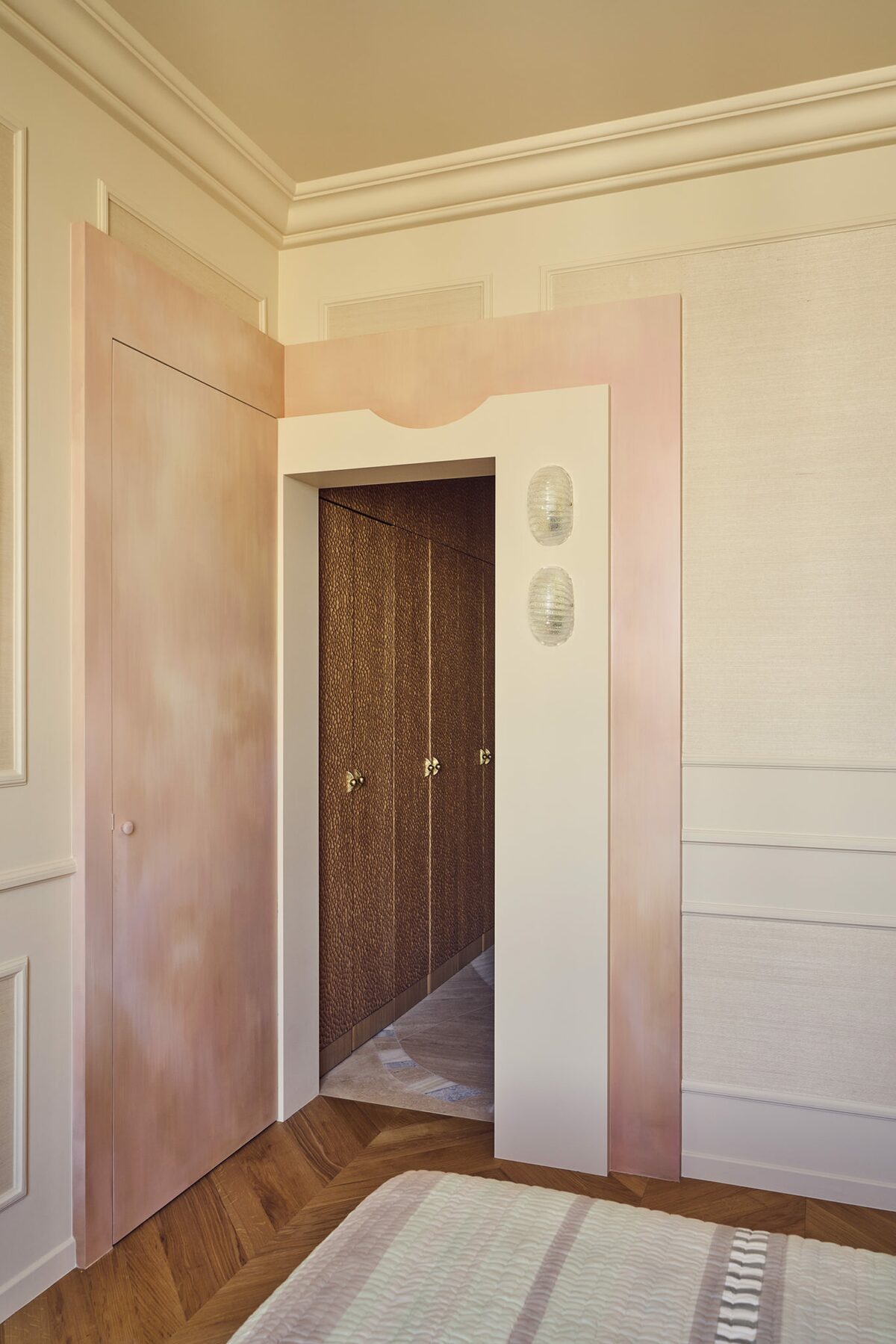 Dressing dans appartement haussmannien avec murs et moulures roses. Rideau rose. Appliques murales en verre. Projet résidentiel Joséphine à Paris signé Batiik Studio.