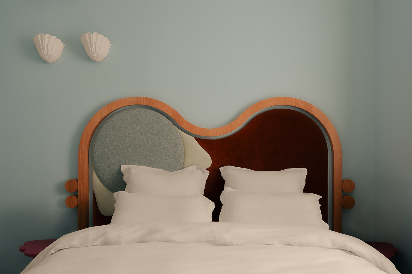 Suite parentale bleu clair avec applique murales coquillages et tête de lit en bois et tissu. Style doux et méditerranéen, fantaisiste. Projet hôtelier Croisette d'Edgar Suite à Cannes réalisé par Batiik Studio.