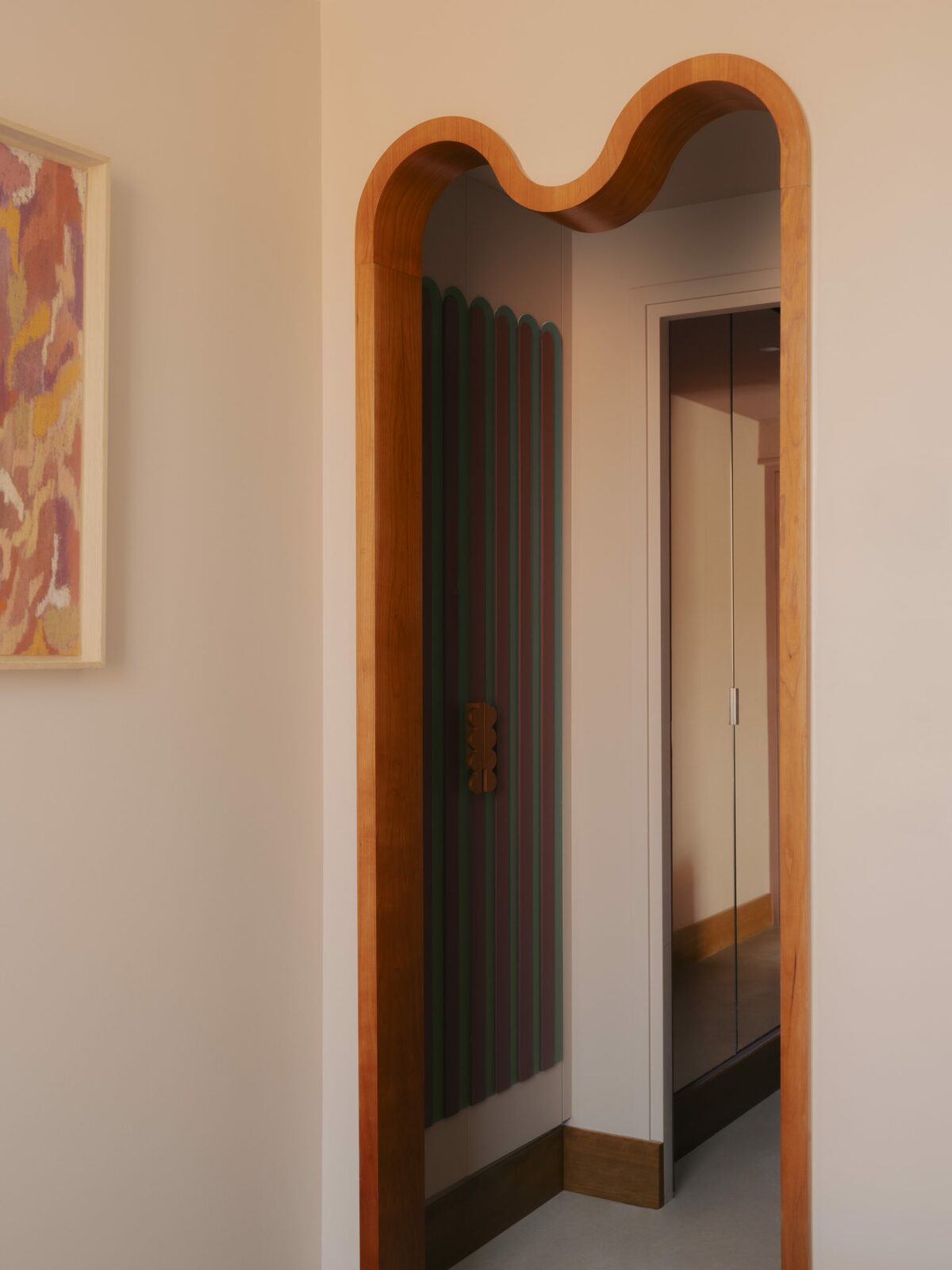 Murs roses pâles et encadrements courbes / arches de portes en bois. Style doux et méditerranéen, fantaisiste. Projet hôtelier Croisette d'Edgar Suite à Cannes réalisé par Batiik Studio.