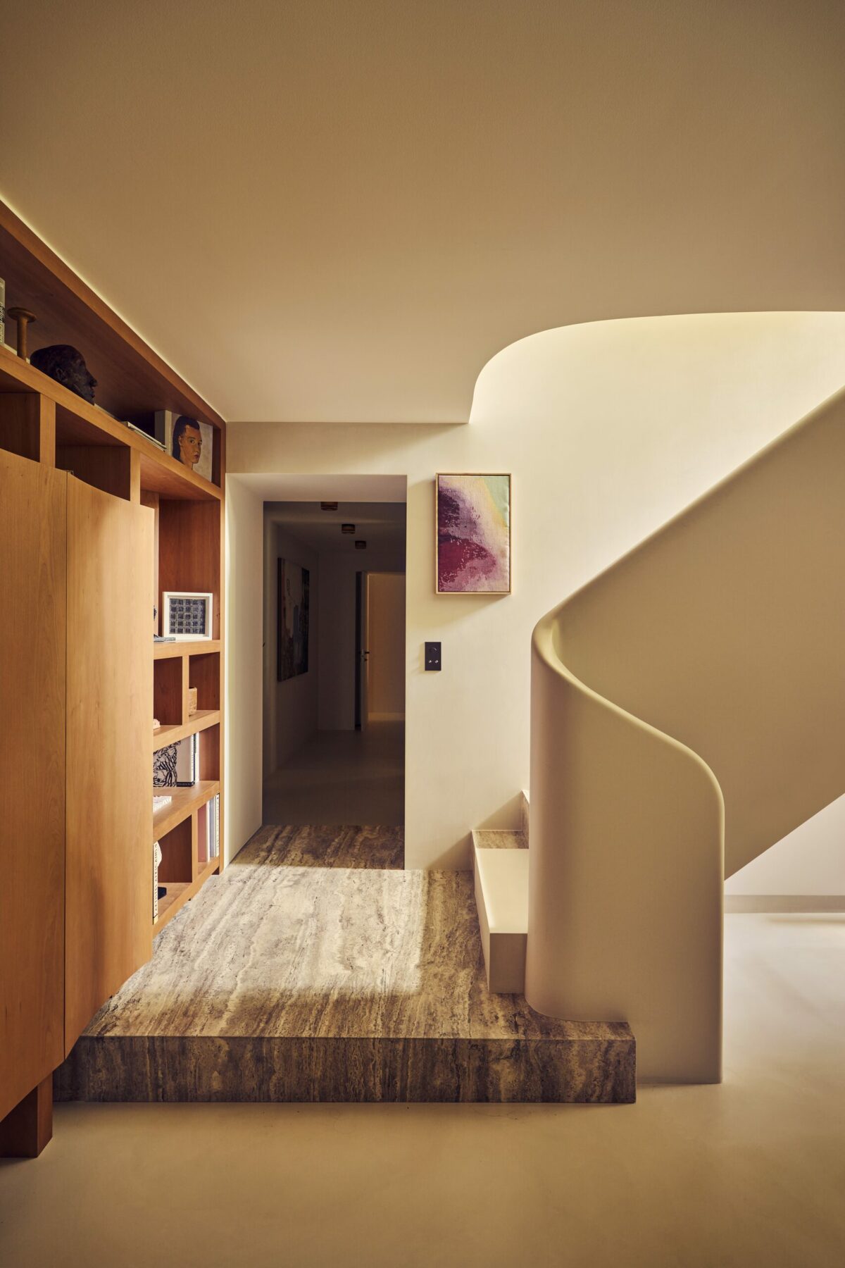 Escalier de duplex avec palier en travertin, résine claire sur le sol et murs enduits à la chaux. Projet Gabriel réalisé par Batiik Studio.