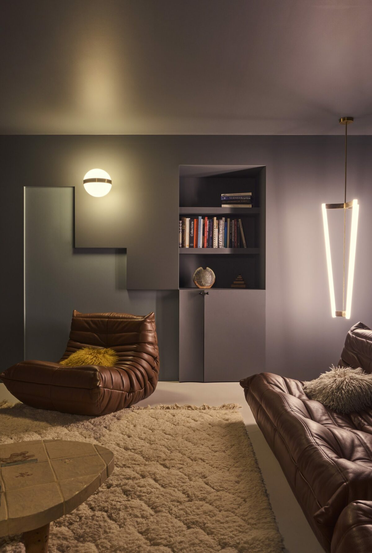 Togo en cuir marron avec applique globulaire et mur anthracite. Projet Gabriel réalisé par Batiik Studio.