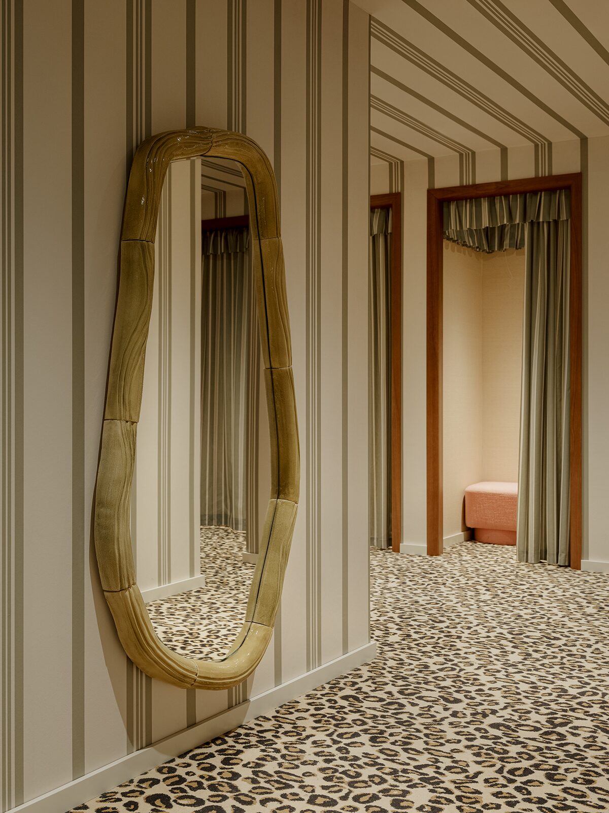 Cabines d'essayage à motifs rayures et moquette imprimé léopard dans l'adresse lyonnaise de Balzac Paris. Miroir réalisé par Pia Chevalier. Un projet réalisé par Batiik Studio pour Balzac Paris dans son adresse lyonnaise.