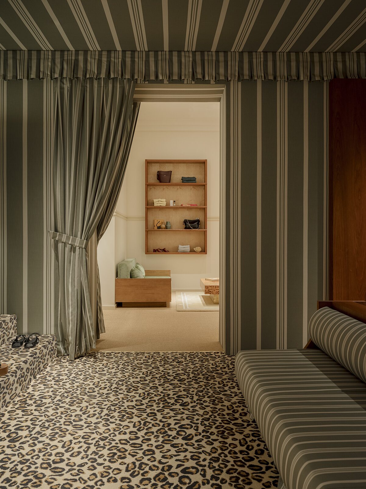 Espace beauté avec moquette léopard, rideaux rayés, banquette à rayures et détail en merisier. Un projet réalisé par Batiik Studio pour Balzac Paris.
